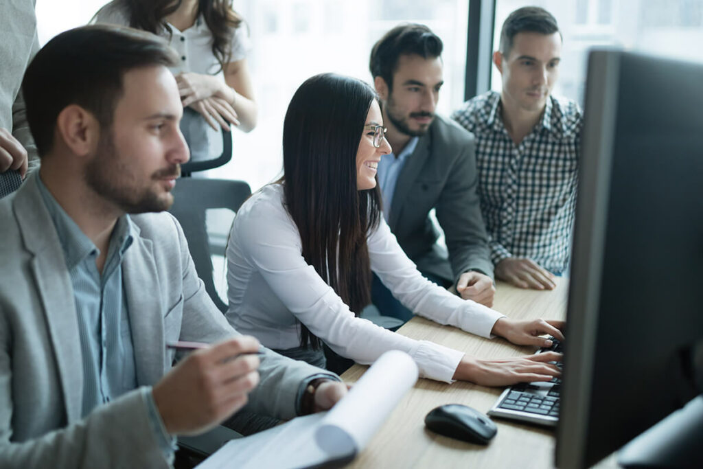 a medium business office with a group of five people using computers and phones with Agilis Networks telecommunication solutions