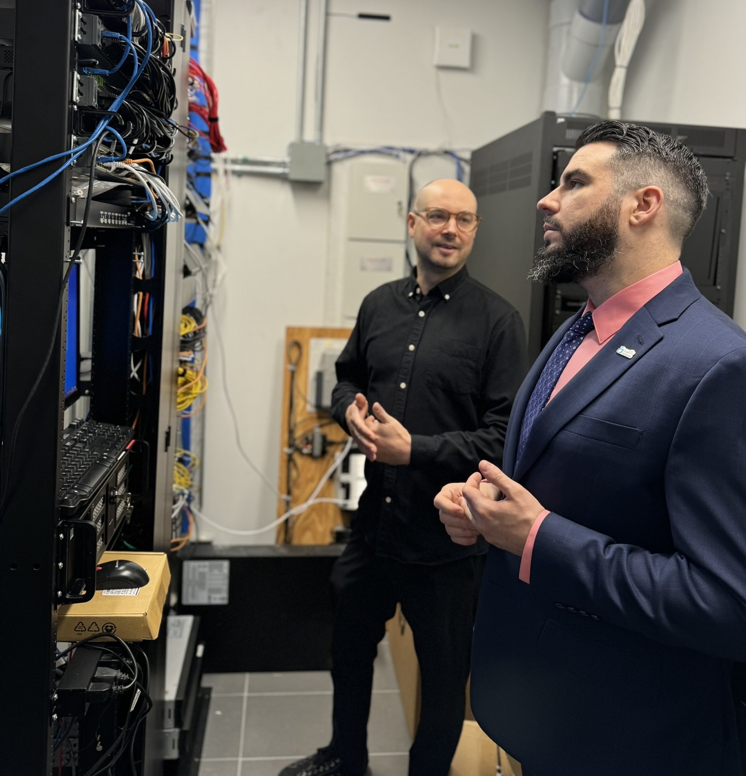 kyle cassidy with client in a server room checking the network connection of Agilis Network telecommunication services 